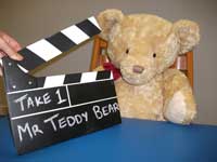 Teddy with a clapper board, about to be filmed