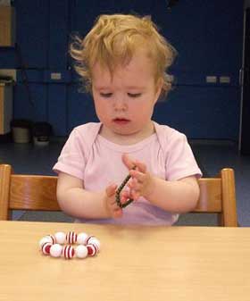 A child plays with a bead bracelet