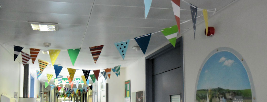 A view down a ward  corridor with little flags hanging from the ceiling