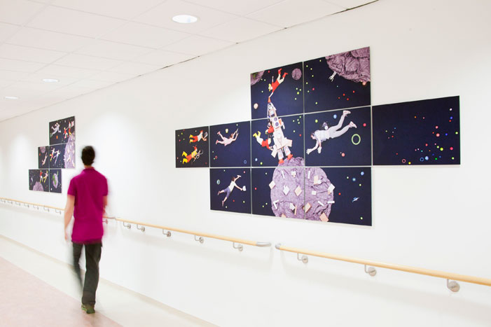 Panels on hospital corridor wall showing collage of child astronauts flying to a paper planet