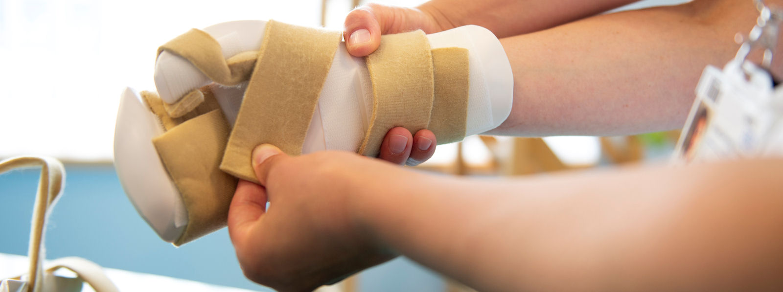 Hands attaching a splint to a child's arm