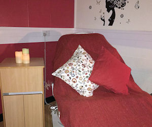 A bed with red cover and side table