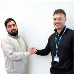 A patient (Waqar) and an OUH member of staff (Daley) shaking hands against a plain background