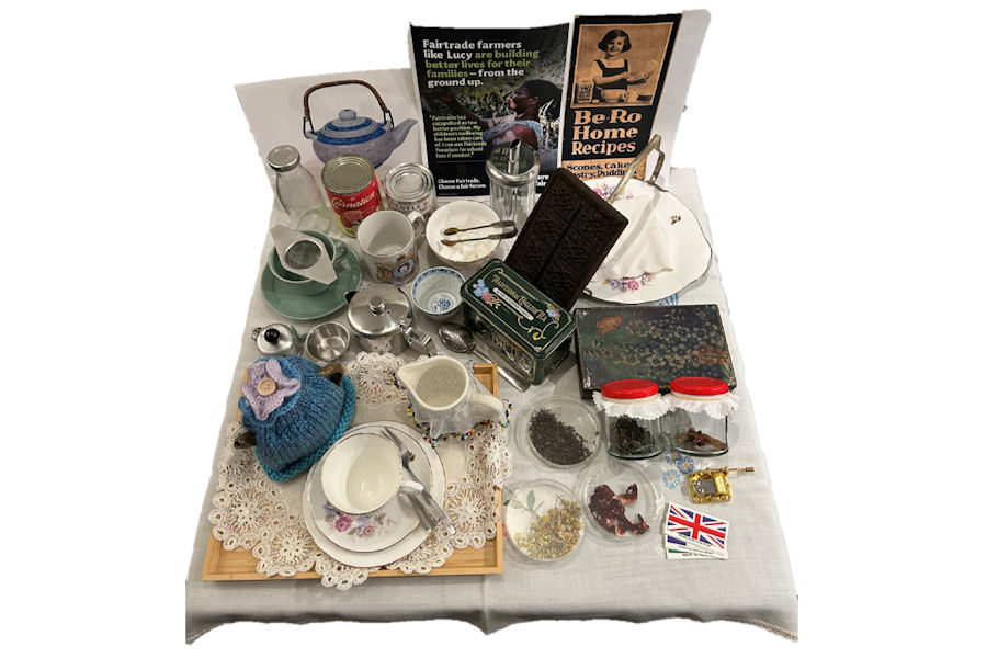 White cloth spread with old-fashioned china and tea-making paraphernalia.