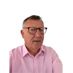 Headshot of Sir Andrew Morris, wearing glasses and a pink shirt against a plain white background