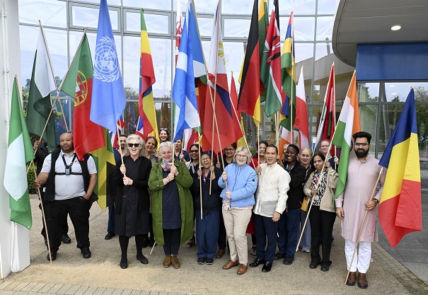 A group of healthcare staff holding flags from different countries across the world