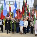 A group of healthcare staff holding flags from different countries across the world