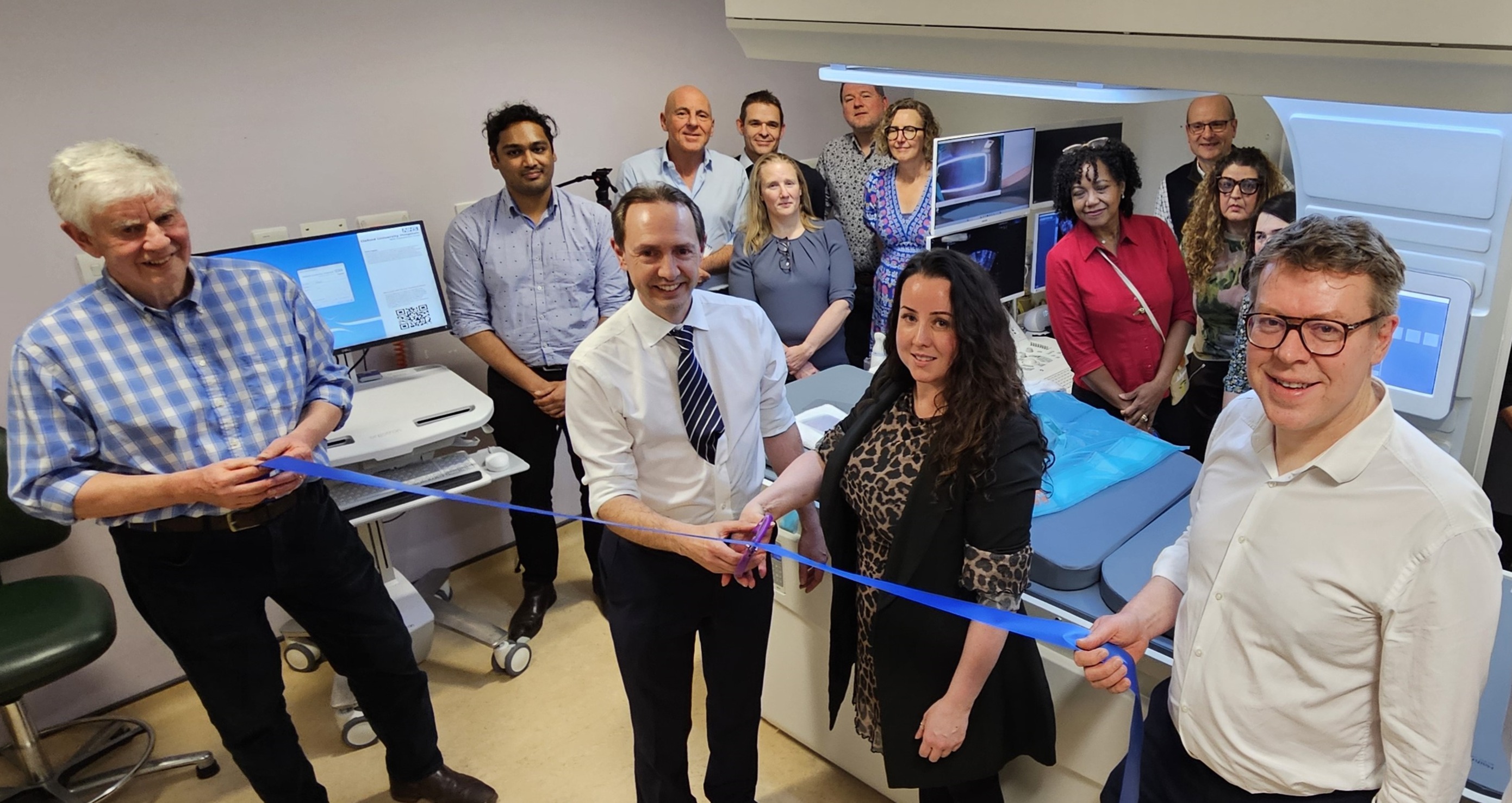 A group of people attending a ribbon-cutting ceremony 