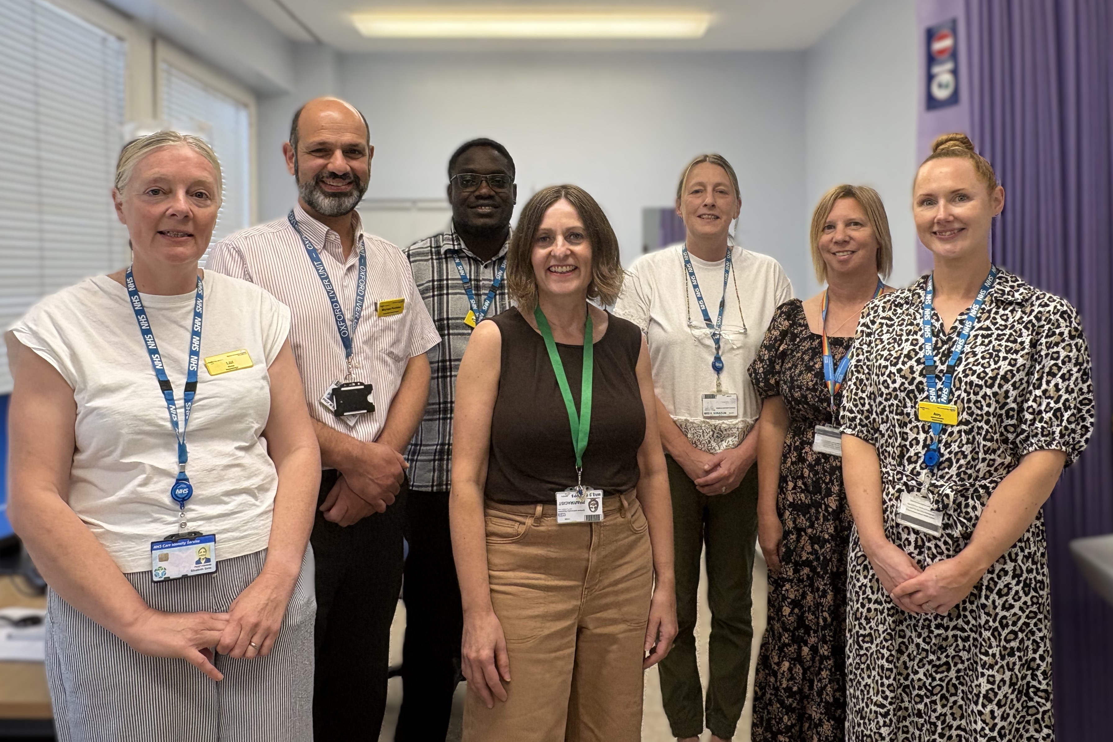 Group of seven people / OUH staff members standing together in a clinical setting.