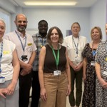 Group of seven people / OUH staff members standing together in a clinical setting.