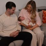 seated man and woman, with woman holding a baby