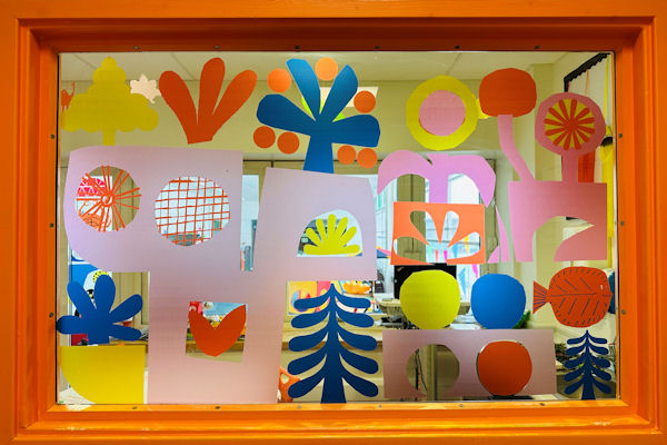 Colourful shapes adhered to a rectangular interior window.