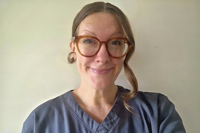 Headshot of Candice Noonan, wearing glasses and a dark medical uniform