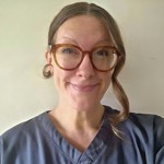 Headshot of Candice Noonan, wearing glasses and a dark medical uniform