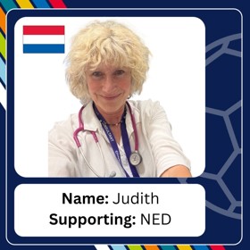 Smiling woman with short messy blonde hair in white coat with stethoscope and lanyard with caption 'Name: Judith; Supporting: NED'.