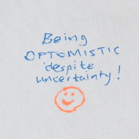 'Being optimistic despite uncertainty' written with a smiley face underneath.