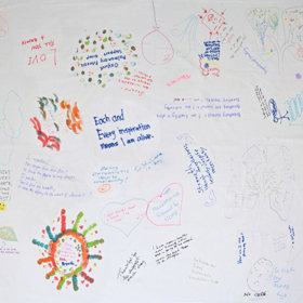 Large plain sheet with drawings and scribbled messages in felt tips all over it.