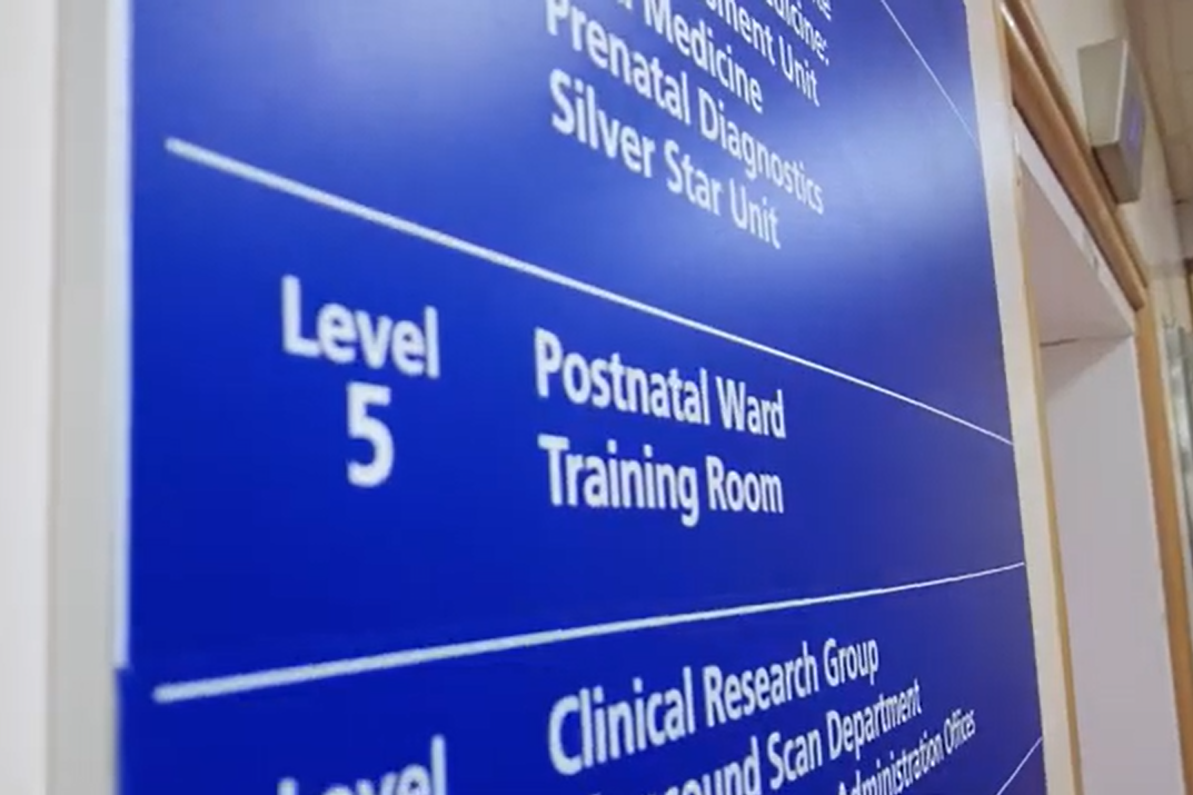 A blue sign with "Level 5, Postnatal Ward" in white letters