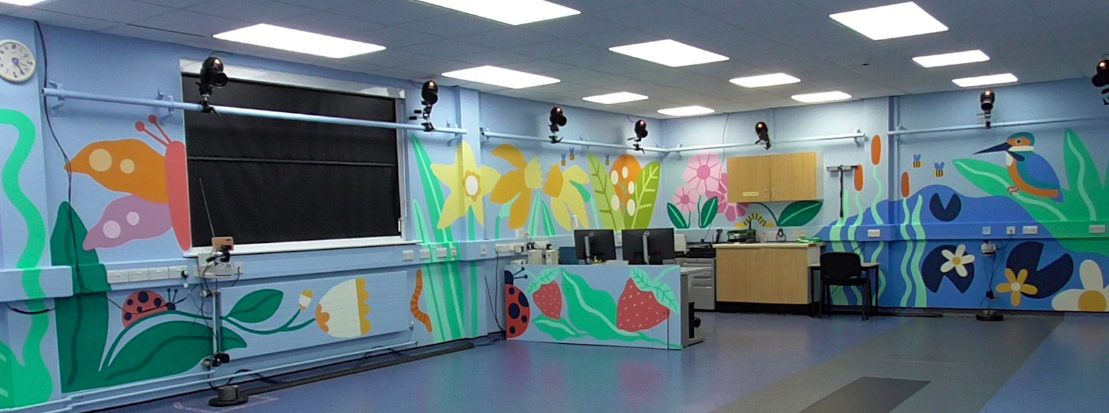 Spacious room with bright mural, shiny floor and camera equipment at edges