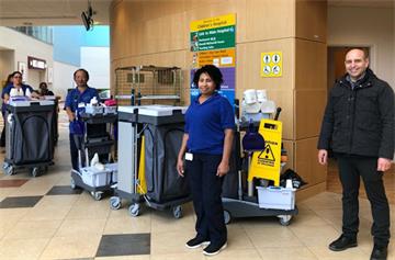 A group of cleaning staff with trolleys in the Children's Hospital atrium