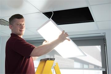 Pavel Janecka, from the OUH Estates team, installs a new LED light at the John Radcliffe Hospital