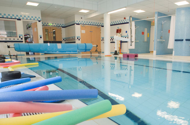 An indoor pool with foam floats in the foreground